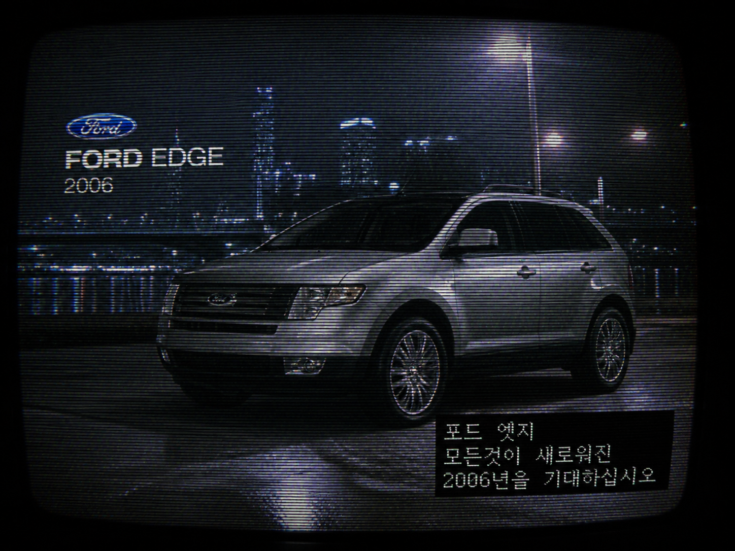 Distorted analog TV screen displaying a lost 2006 Ford Edge car commercial with Korean subtitles and broadcast artifacts.