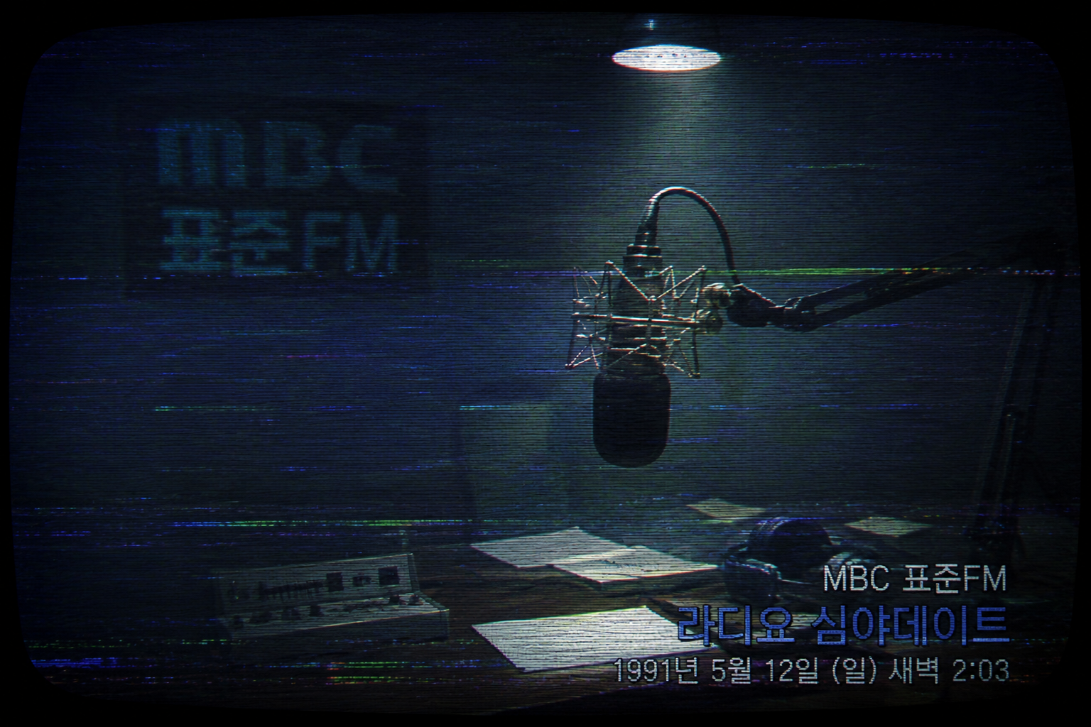 Low-resolution 1991 Korean television broadcast screenshot displaying an empty radio microphone with heavy VHS tracker artifacts and matted blue lighting.