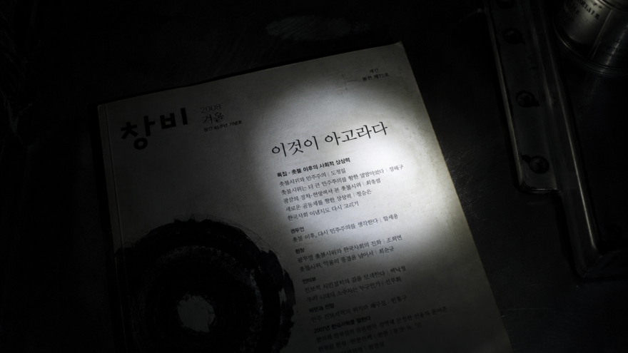The 3AM Incident: Inside the Erasure of ‘The Bored Window’ Labeled print edition of a 2008 Korean literary quarterly illuminated under a flashlight beam in a dark room.