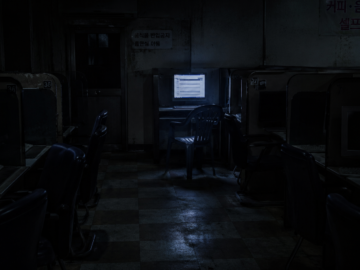 The Blender Phantom: The Lost 2009 Korean Internet Shock Video That Police Couldn’t Trace A dark, empty cyber cafe room at night with a single glowing computer monitor showing a broken internet forum interface.